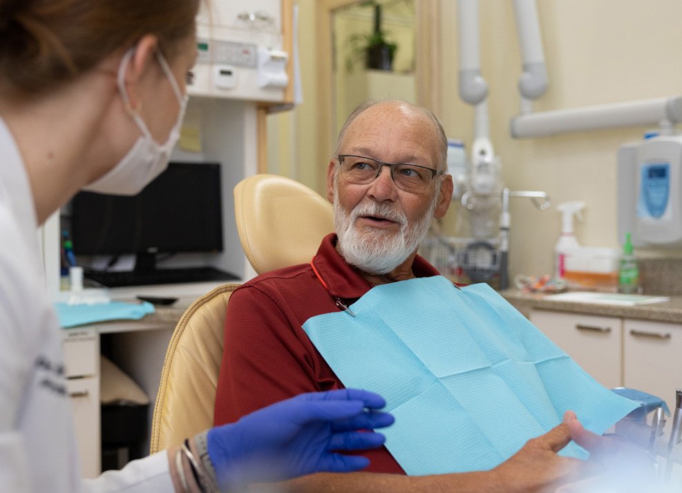 Dental patient talking with dentist about dentures