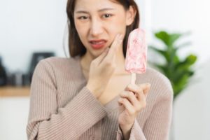 Woman suffering from a tooth sensitivity cause by ice cream